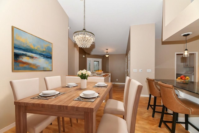 dining room featuring a chandelier, washer / clothes dryer, and baseboards