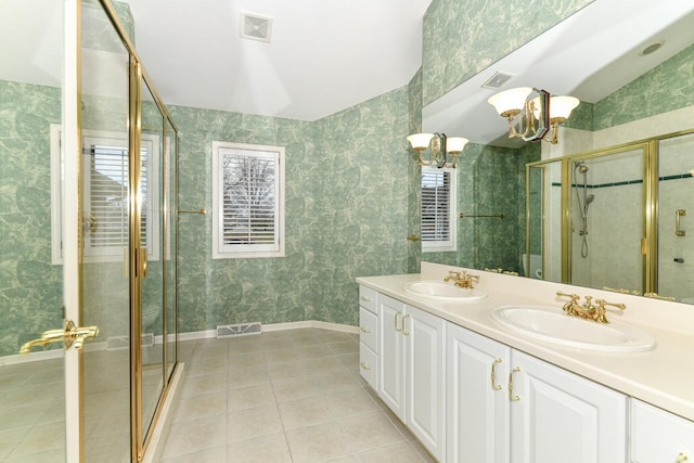 bathroom featuring tile patterned flooring, double vanity, visible vents, and a sink