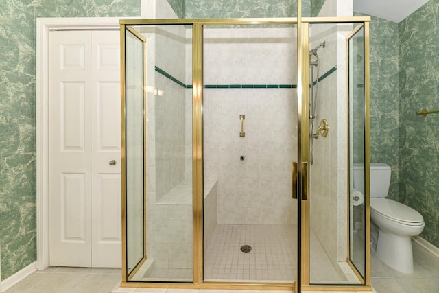 bathroom featuring wallpapered walls, baseboards, toilet, a stall shower, and tile patterned floors