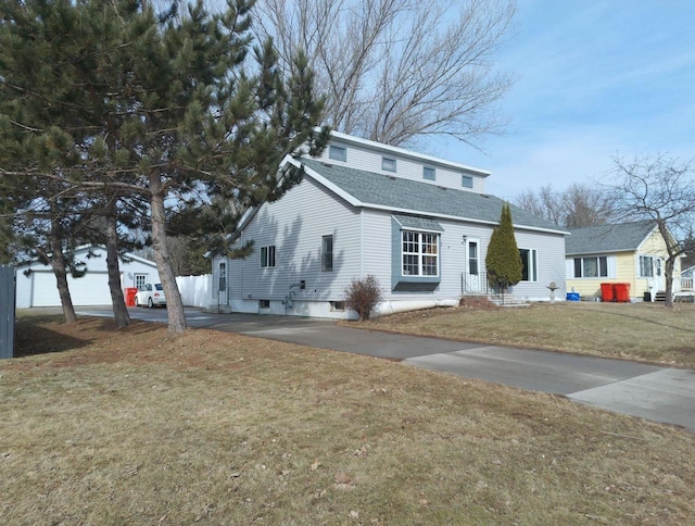 traditional-style house with roof with shingles, concrete driveway, and a front lawn