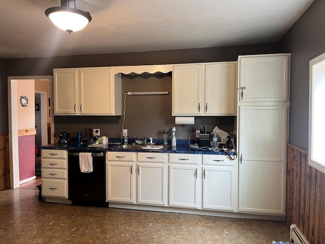 kitchen with dark countertops, a wainscoted wall, dishwasher, baseboard heating, and white cabinetry