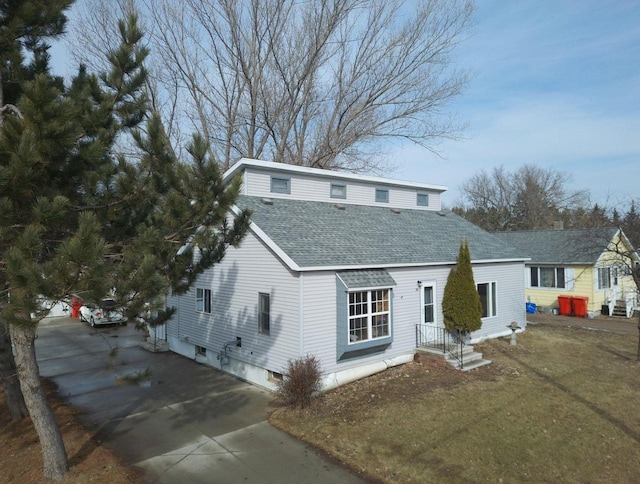 view of front of property with concrete driveway and roof with shingles