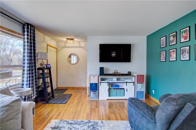 living area with light wood-style flooring and baseboards