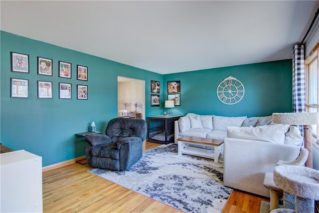 living area with baseboards and wood finished floors