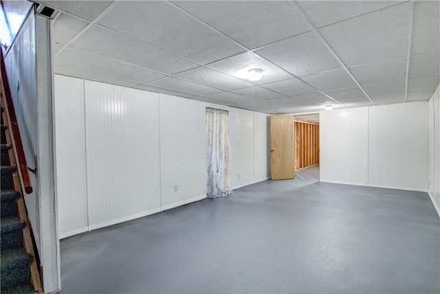 basement featuring stairway and a drop ceiling