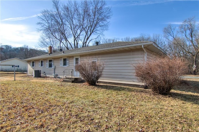 rear view of house featuring a yard and central AC unit