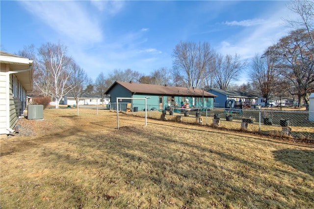 view of yard featuring central AC and fence