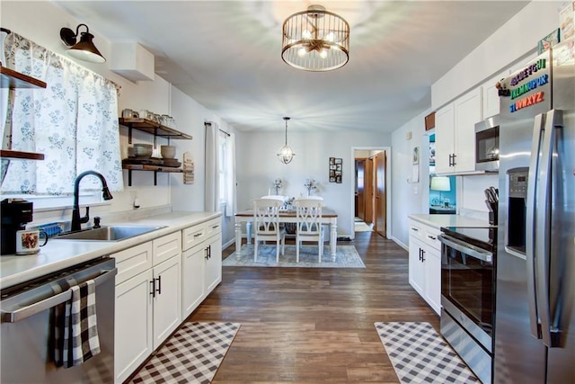 kitchen featuring open shelves, light countertops, stainless steel appliances, and a sink