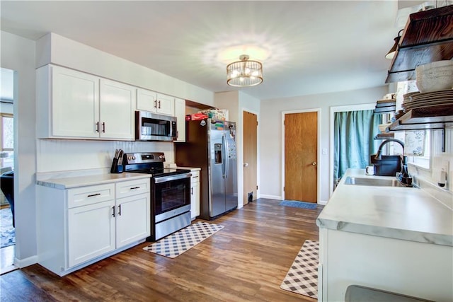 kitchen featuring light countertops, an inviting chandelier, white cabinets, stainless steel appliances, and a sink