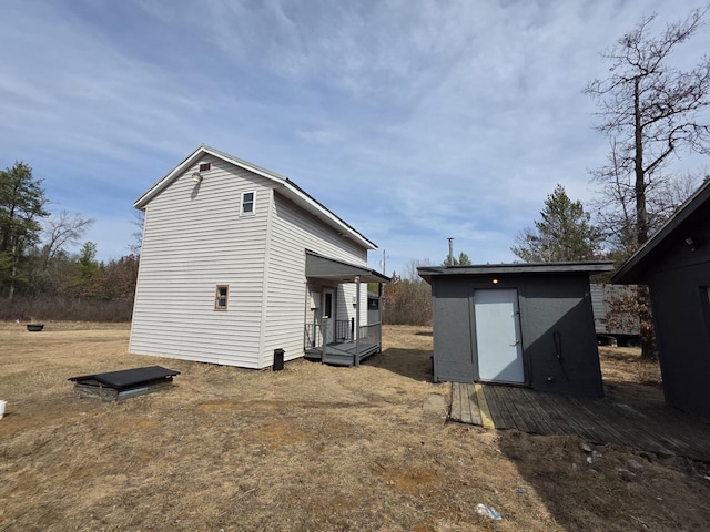 back of house with an outbuilding and a storage shed