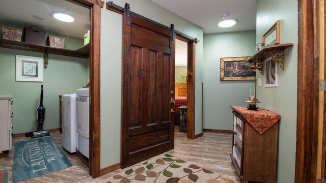 204629 Lake Dr, Rosholt, WI 54473 - laundry area featuring baseboards, a barn door, laundry area, light wood-style flooring, and independent washer and dryer