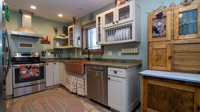 204629 Lake Dr, Rosholt, WI 54473 - kitchen with a sink, dark countertops, white cabinetry, stainless steel appliances, and wall chimney range hood