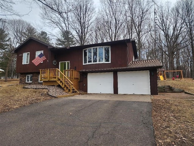 bi-level home featuring aphalt driveway and an attached garage