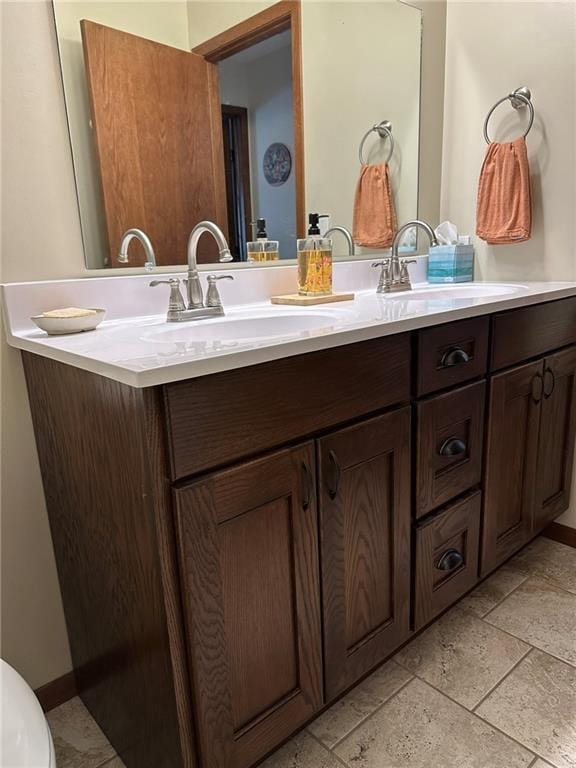 bathroom with stone tile flooring and vanity