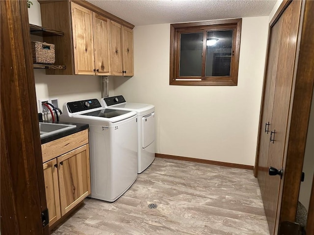 laundry area with washer and dryer, baseboards, cabinet space, and a textured ceiling