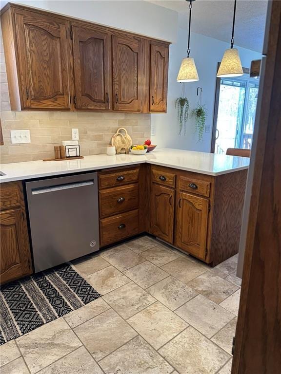 kitchen with dishwasher, light countertops, a peninsula, and tasteful backsplash