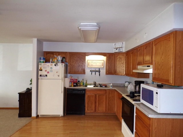 kitchen featuring white appliances, a sink, light wood-style floors, under cabinet range hood, and brown cabinets