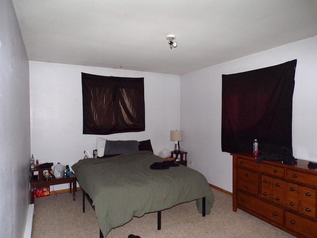 bedroom with baseboards and light carpet