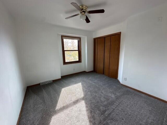 20530 84th Pl, Bristol, WI 53104 - unfurnished bedroom featuring visible vents, baseboards, carpet flooring, a closet, and a ceiling fan