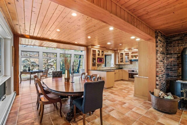 dining space with a wood stove, light tile patterned floors, recessed lighting, wooden ceiling, and a baseboard radiator