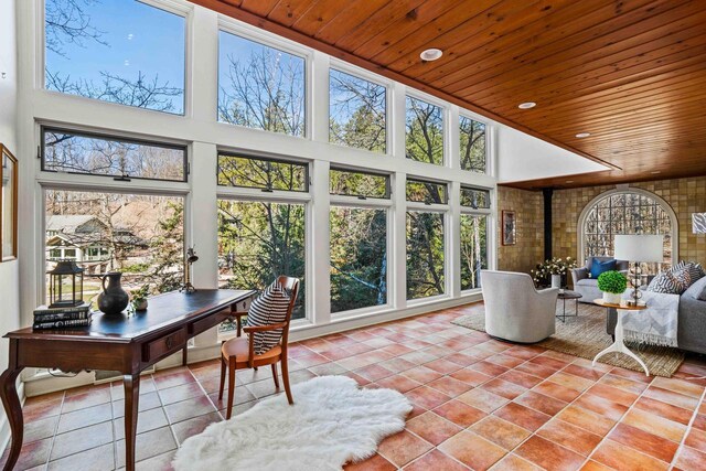 sunroom featuring wooden ceiling, a high ceiling, and tile patterned flooring