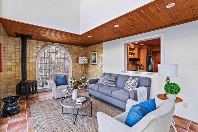 living room featuring wooden ceiling, a wood stove, tile patterned flooring, and recessed lighting