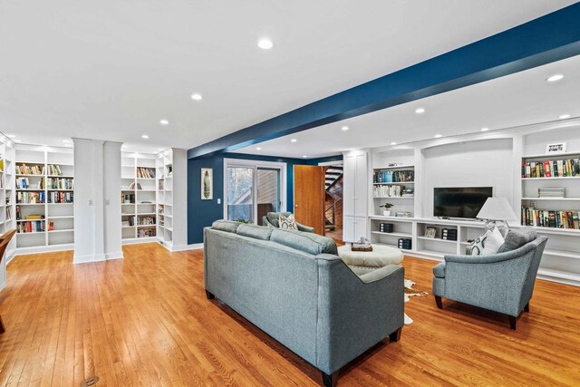 living room featuring built in features, light wood-type flooring, ornate columns, and recessed lighting
