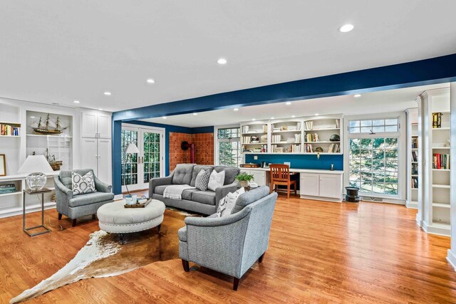 living area featuring recessed lighting, light wood-style flooring, beam ceiling, and a healthy amount of sunlight