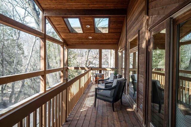 unfurnished sunroom featuring a skylight