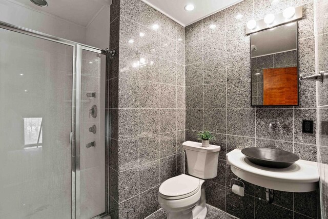 bathroom featuring a shower stall, tile walls, and toilet