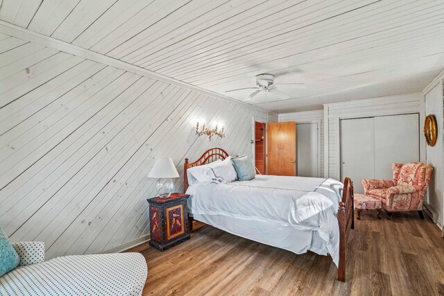 bedroom featuring a closet, baseboards, a ceiling fan, and wood finished floors