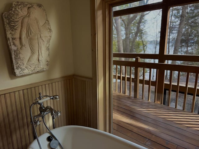interior space with a soaking tub and wainscoting