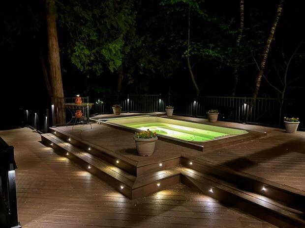 exterior space featuring an in ground hot tub and fence