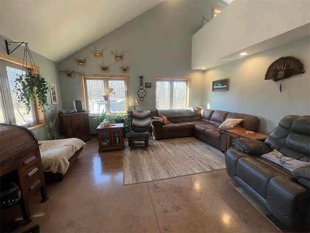 living area with plenty of natural light and high vaulted ceiling