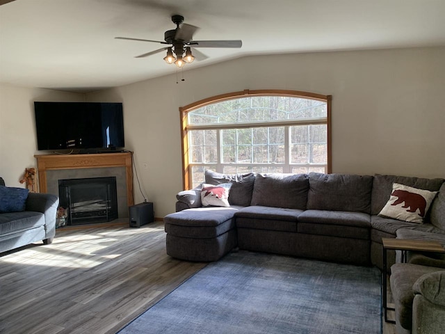 living area with a fireplace, wood finished floors, and a ceiling fan