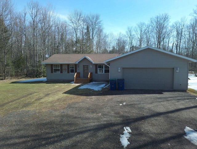 ranch-style house featuring aphalt driveway, an attached garage, and a front yard