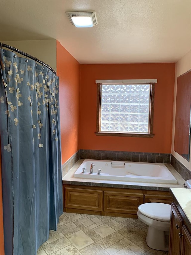 full bathroom with visible vents, toilet, vanity, a bath, and a textured ceiling