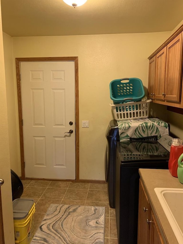 laundry area featuring light tile patterned flooring, a sink, cabinet space, and separate washer and dryer