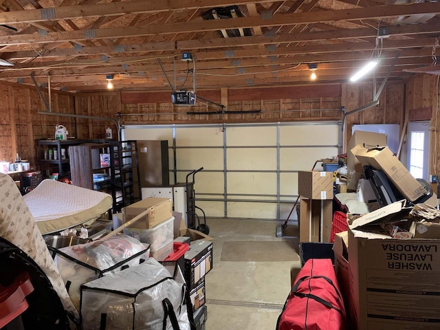 garage featuring wood walls and a garage door opener