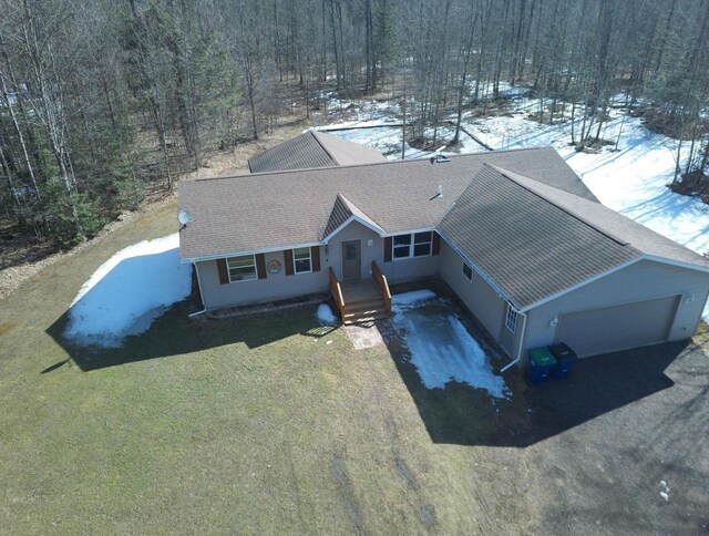 snowy aerial view featuring a wooded view