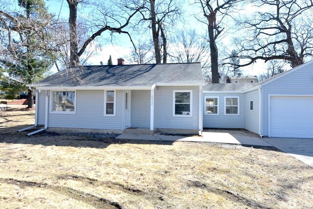 ranch-style house with a garage, driveway, and a chimney