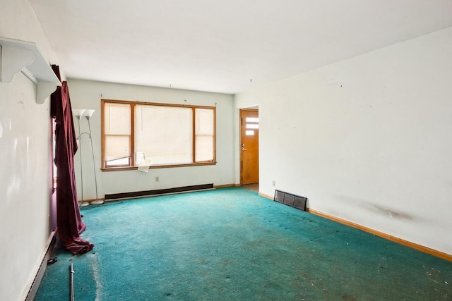 empty room with carpet, visible vents, baseboard heating, and baseboards