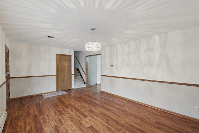5607 Alben Ave, Mcfarland, WI 53558 - empty room featuring visible vents, a baseboard heating unit, a chandelier, stairway, and wood finished floors