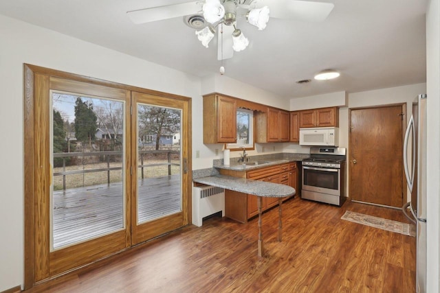 5607 Alben Ave, Mcfarland, WI 53558 - kitchen with brown cabinets, dark wood-type flooring, a sink, appliances with stainless steel finishes, and ceiling fan