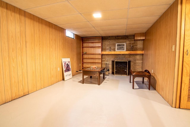 W9404 Porter Dr Unit W9408, Cambridge, WI 53523 - living area featuring a stone fireplace, wooden walls, a drop ceiling, and finished concrete floors