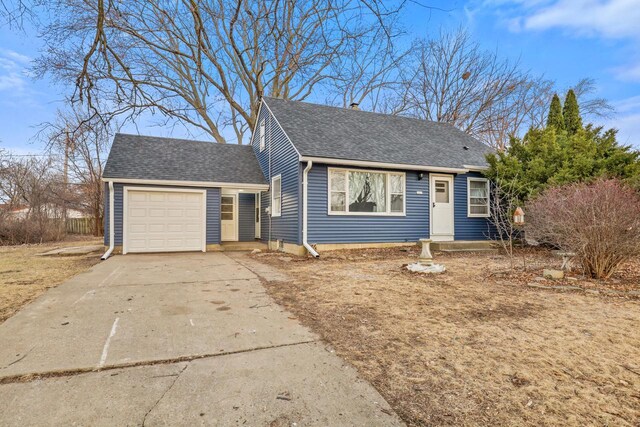 view of front facade featuring an attached garage, a shingled roof, and concrete driveway