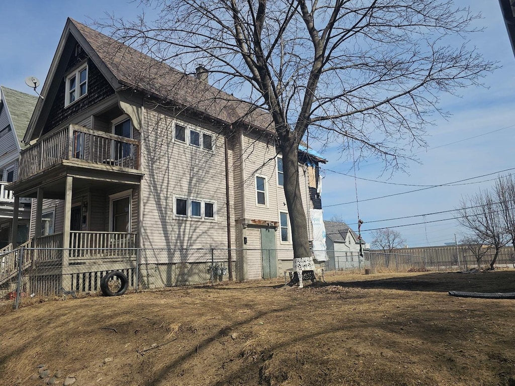 view of property exterior featuring a balcony and a chimney