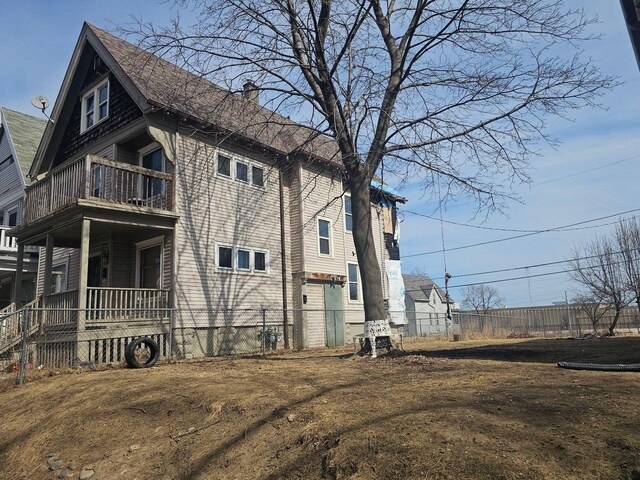 view of property exterior featuring a balcony and a chimney