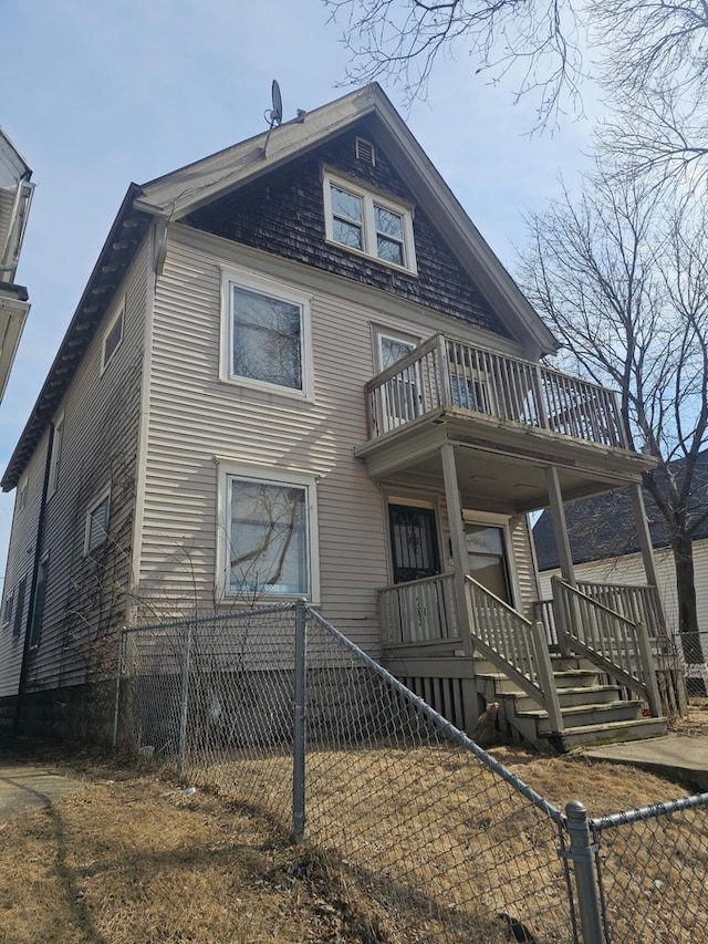 view of front of home with a fenced front yard and a balcony