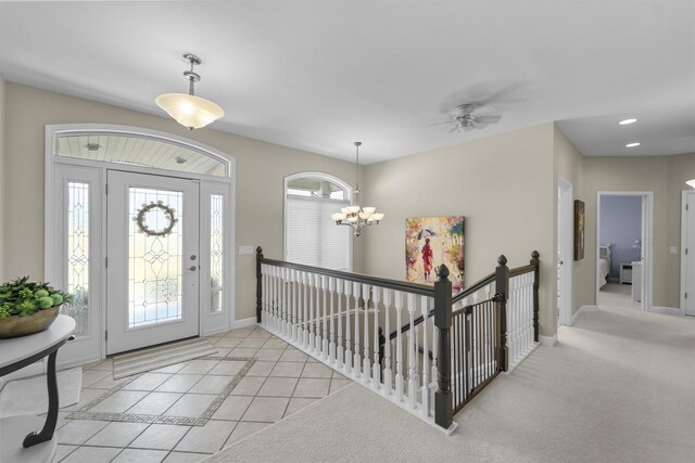 entryway with light tile patterned floors, recessed lighting, ceiling fan with notable chandelier, and baseboards